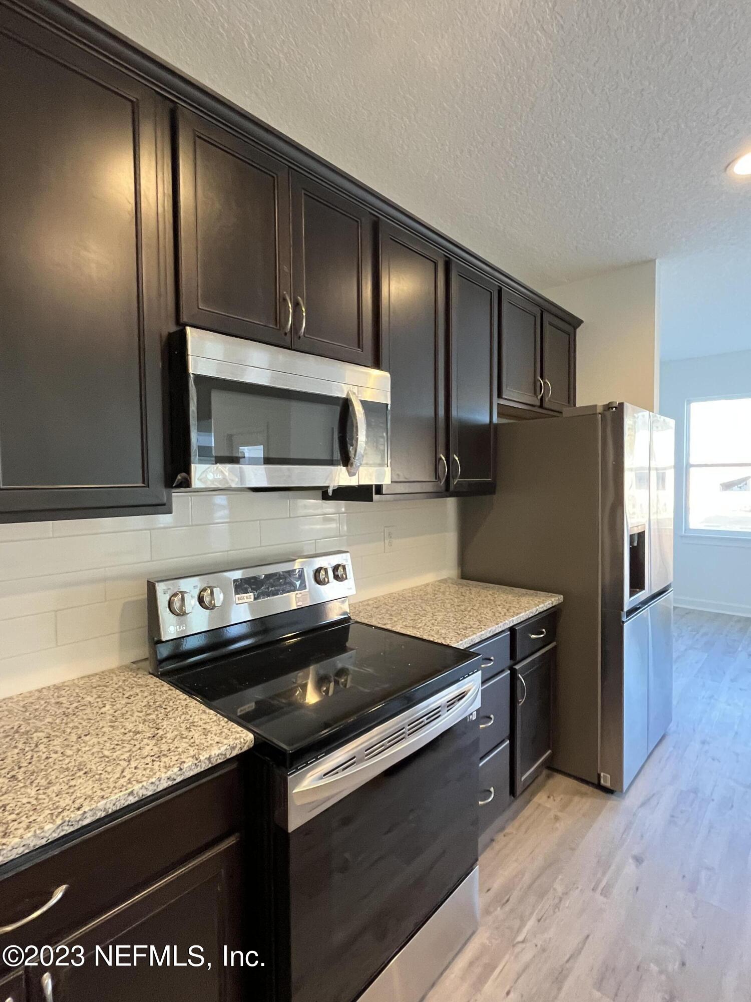 3051 Orange Picker Road Jacksonville, FL 32223 - Photo 7 of 7 a kitchen with stainless steel appliances granite countertop a sink stove and refrigerator