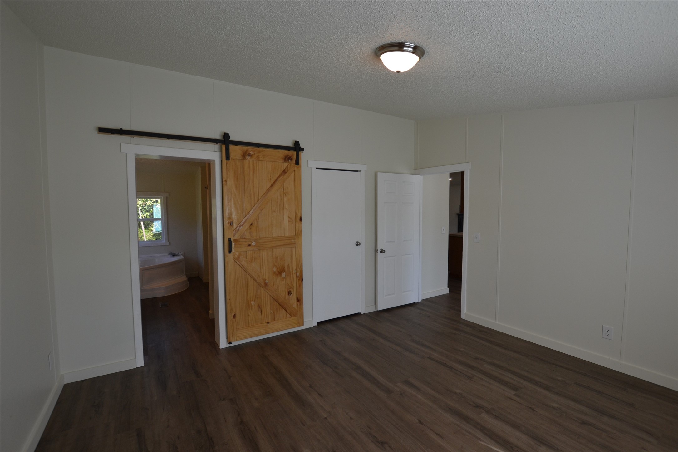 13402 U.S. Highway 190 Onalaska, TX 77360 - Photo 11 of 16 a view of an empty room with wooden floor and a bathroom