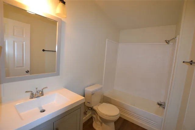 a bathroom with a sink toilet vanity and tub