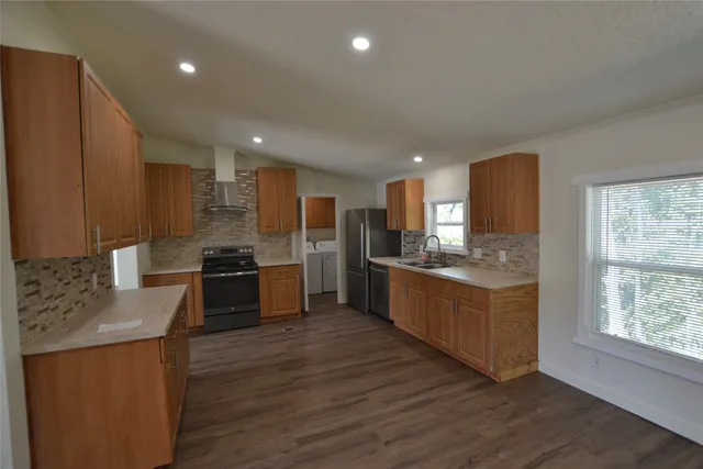 a kitchen with stainless steel appliances kitchen island granite countertop a stove a sink and a refrigerator