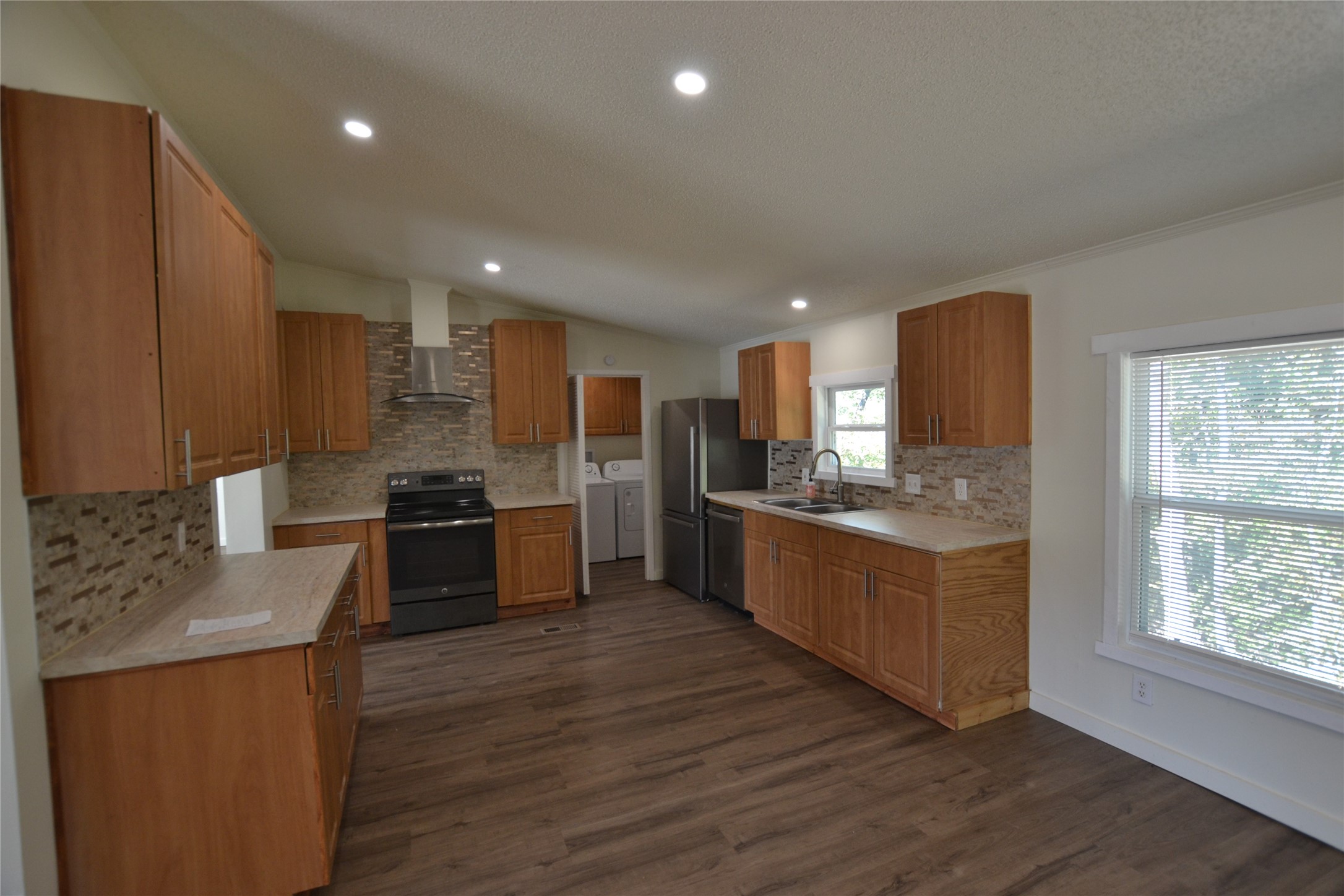 13402 U.S. Highway 190 Onalaska, TX 77360 - Photo 5 of 16 a kitchen with stainless steel appliances kitchen island granite countertop a stove a sink and a refrigerator