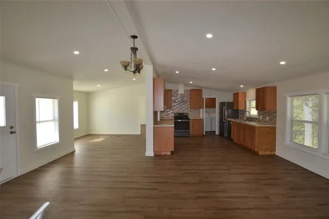 a view of kitchen with kitchen island wooden floor center island and stainless steel appliances