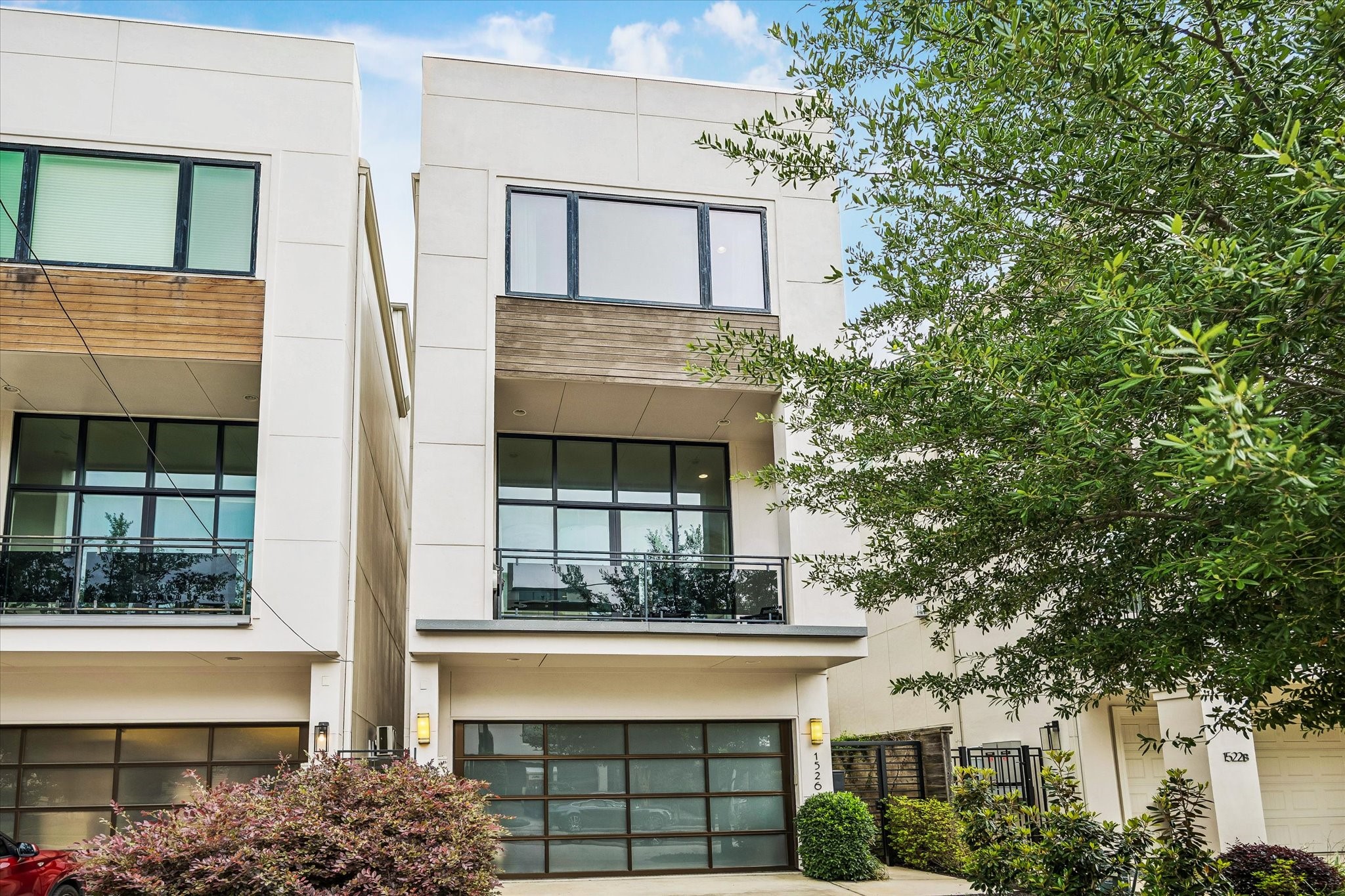 Striking front elevation with clean contemporary lines, expansive windows, and a modern glass-paneled balcony.