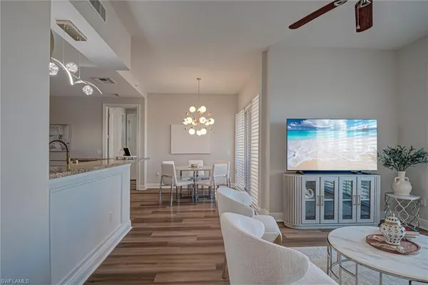 a living room with furniture a rug and kitchen view