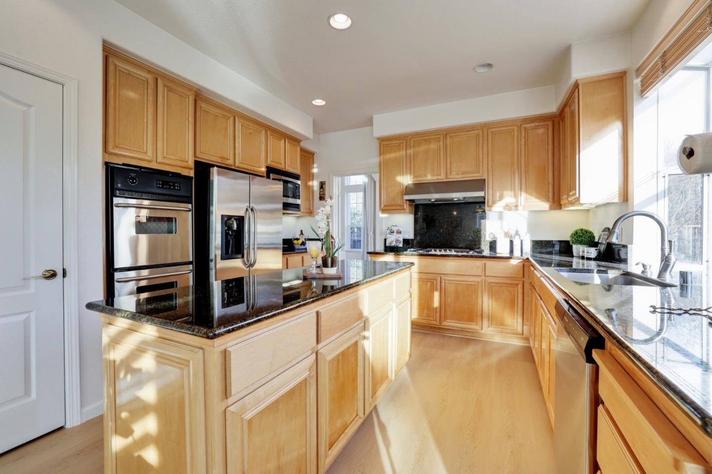313 Lower Vintners Circle Fremont, CA 94539 - Photo 16 of 50 a kitchen with stainless steel appliances a sink a stove top oven a counter space and cabinets