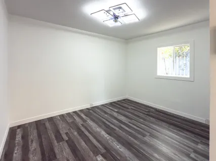 a view of empty room with wooden floor