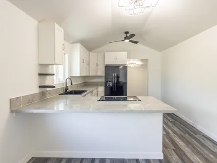a kitchen with kitchen island a sink stainless steel appliances and white cabinets