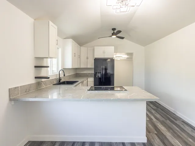 a kitchen with kitchen island a sink stainless steel appliances and white cabinets