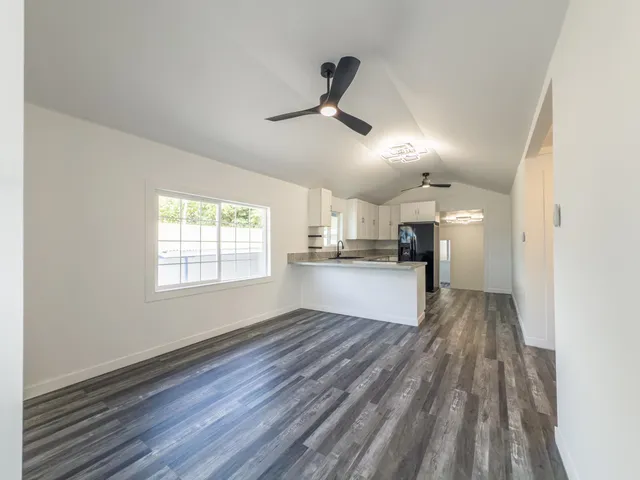 a view of empty room with wooden floor and window