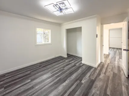 a view of a livingroom with wooden floor and a window