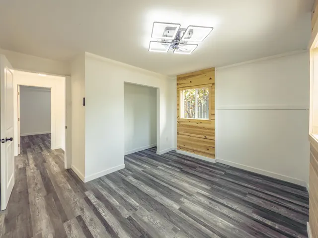 a view of a room with wooden floor and ceiling fan