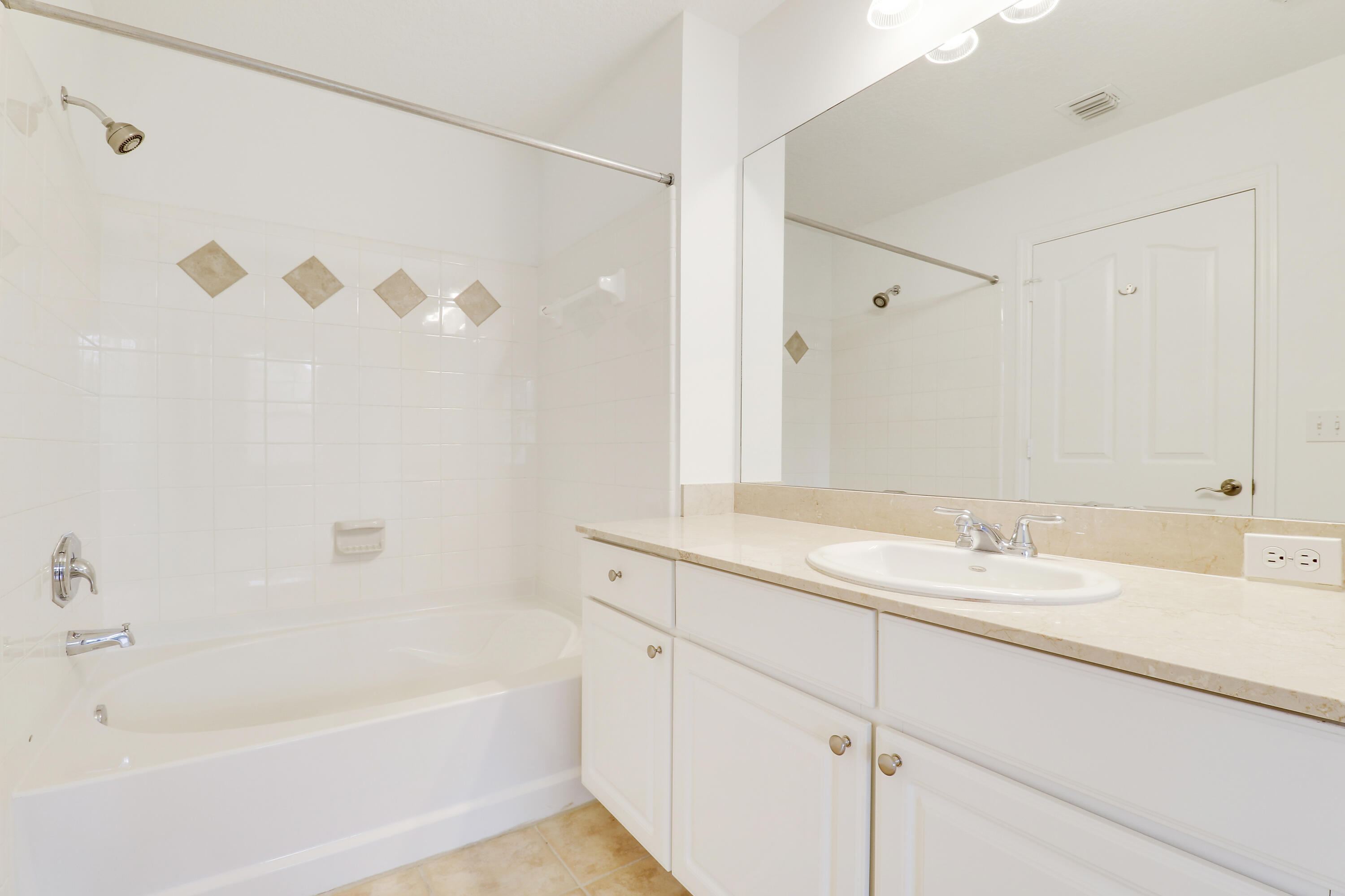 225 Murcia Drive, Unit 307 Jupiter, FL 33458 - Photo 22 of 36 a bathroom with a granite countertop sink a mirror a shower and a bathtub
