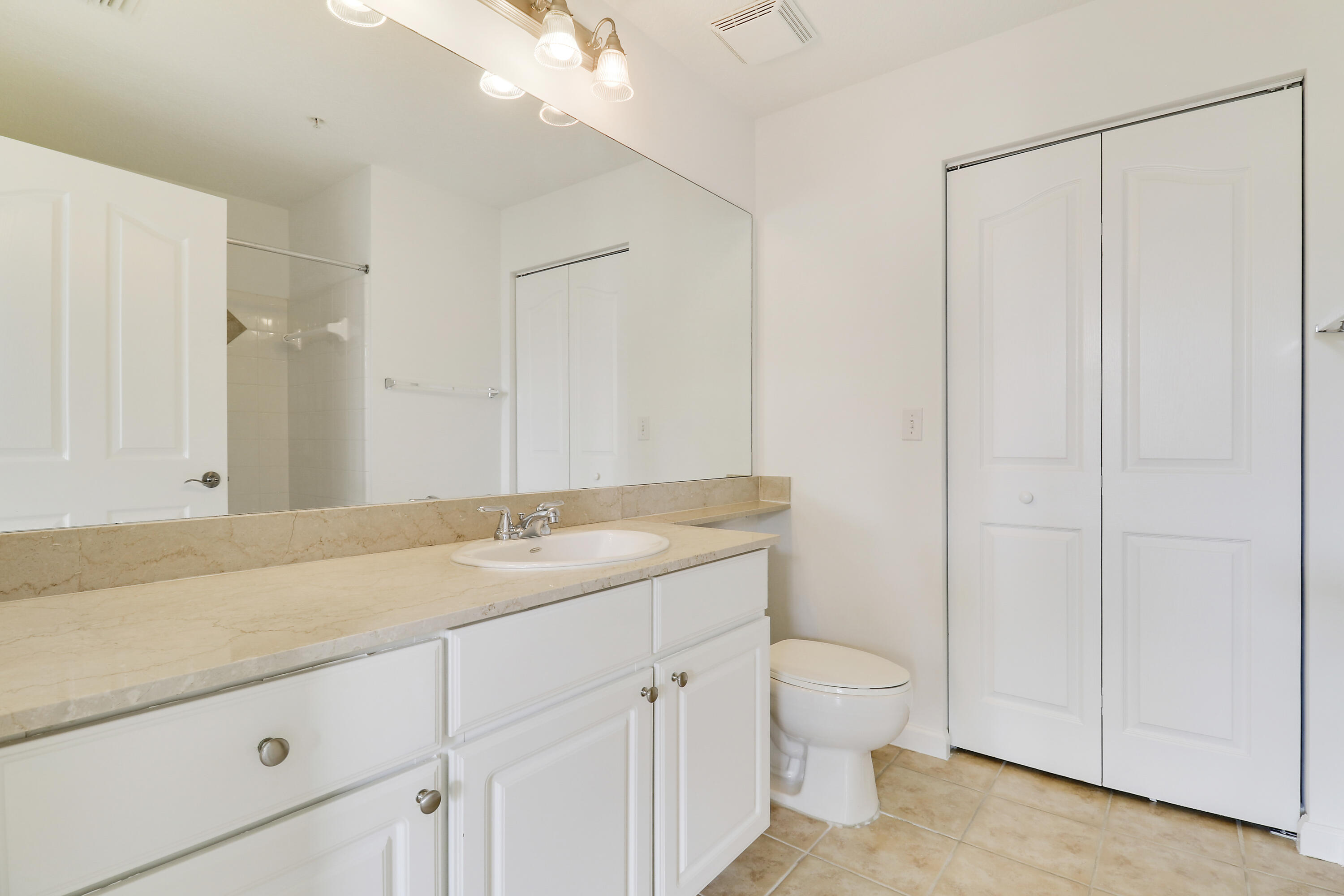 225 Murcia Drive, Unit 307 Jupiter, FL 33458 - Photo 26 of 36 a bathroom with a granite countertop sink a toilet and a shower