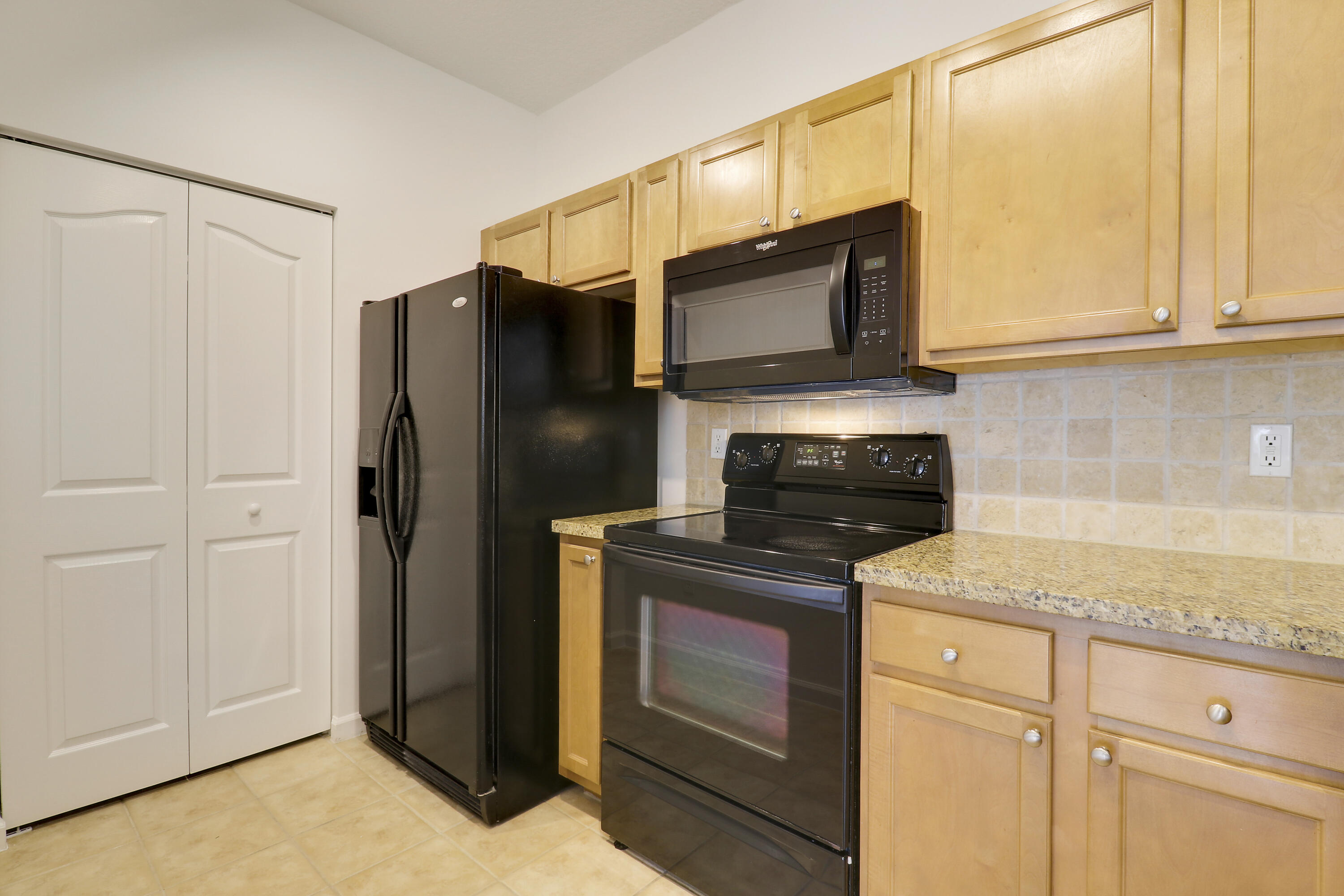 225 Murcia Drive, Unit 307 Jupiter, FL 33458 - Photo 29 of 36 a kitchen with stainless steel appliances granite countertop white cabinets and a stove top oven