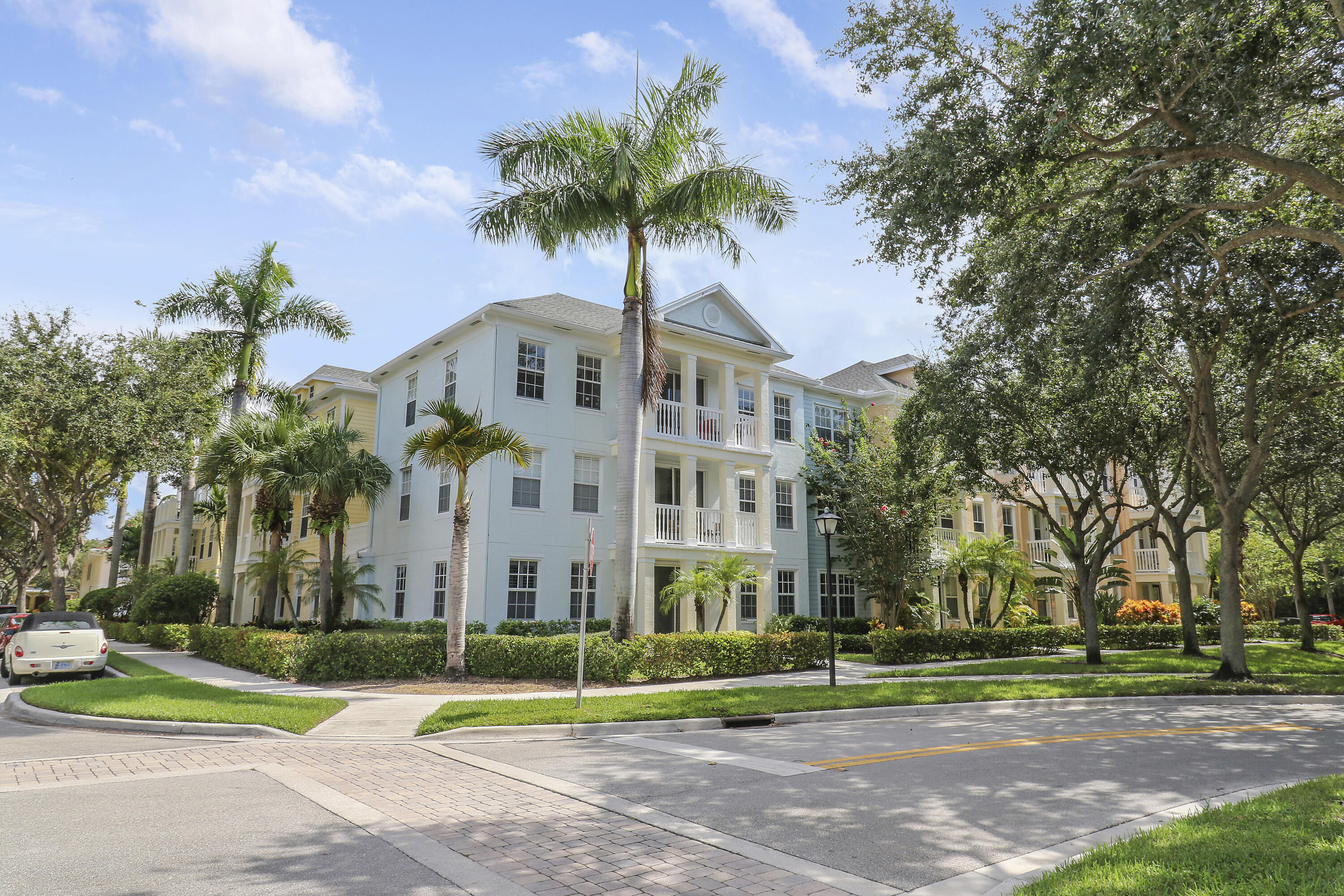 225 Murcia Drive, Unit 307 Jupiter, FL 33458 - Photo 34 of 36 a view of a tall white house with a big yard and palm trees