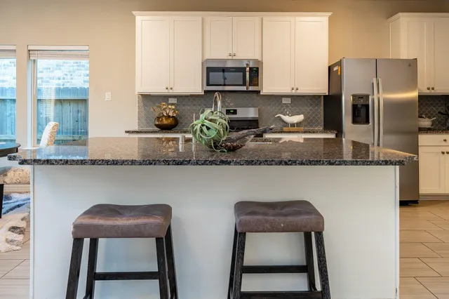 a kitchen with stainless steel appliances granite countertop a stove a sink and a refrigerator