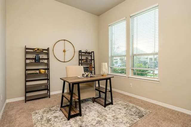 a view of a workspace with furniture and a window
