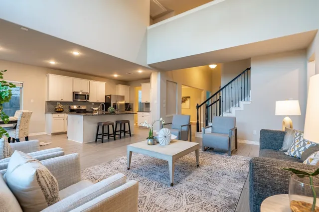 a living room with furniture kitchen view and a table