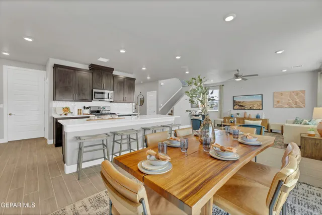a open dining room with kitchen island furniture a sink a rug and a window