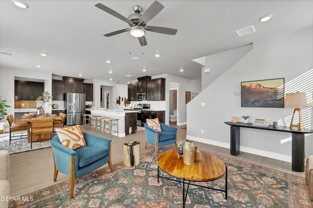 a living room with furniture kitchen view and a chandelier