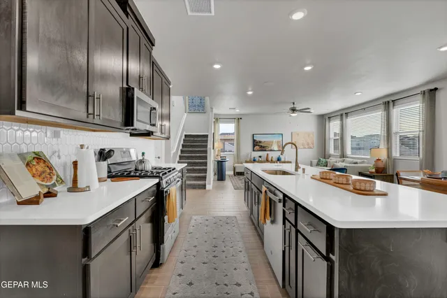 a kitchen with stainless steel appliances granite countertop a sink stove and refrigerator