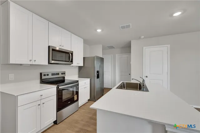 a kitchen with a sink a stove and refrigerator