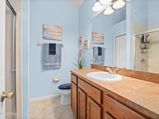 a bathroom with a granite countertop sink a toilet and a mirror