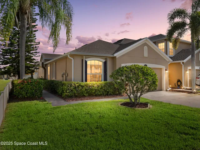 a front view of a house with a garden and yard
