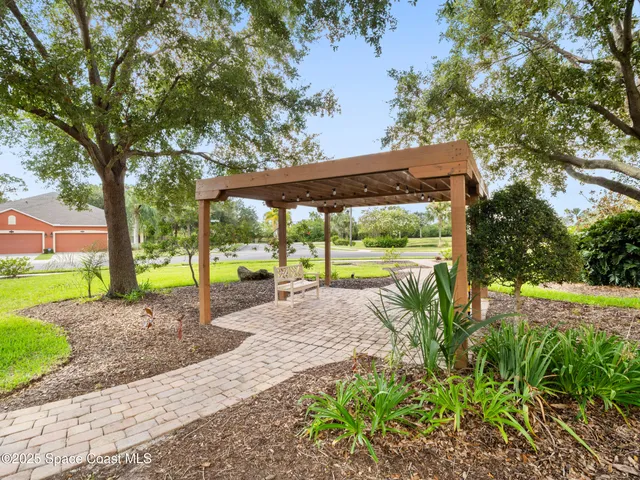 a view of a house with backyard and a large tree