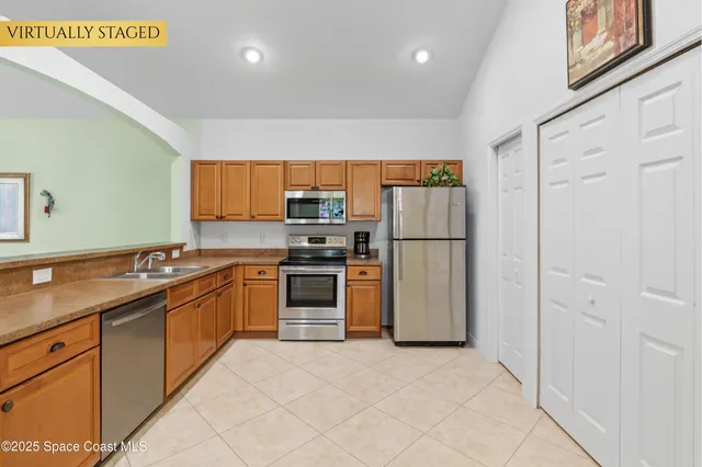 a kitchen with stainless steel appliances granite countertop a refrigerator sink and stove