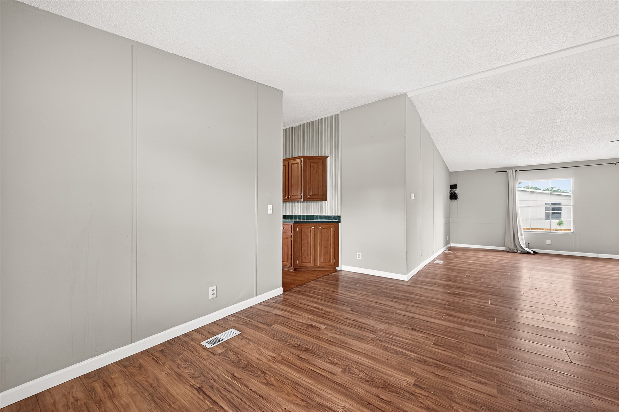 5982 Waukegan Road Conroe, TX 77306 - Photo 12 of 49 a view of an empty room with wooden floor and a window