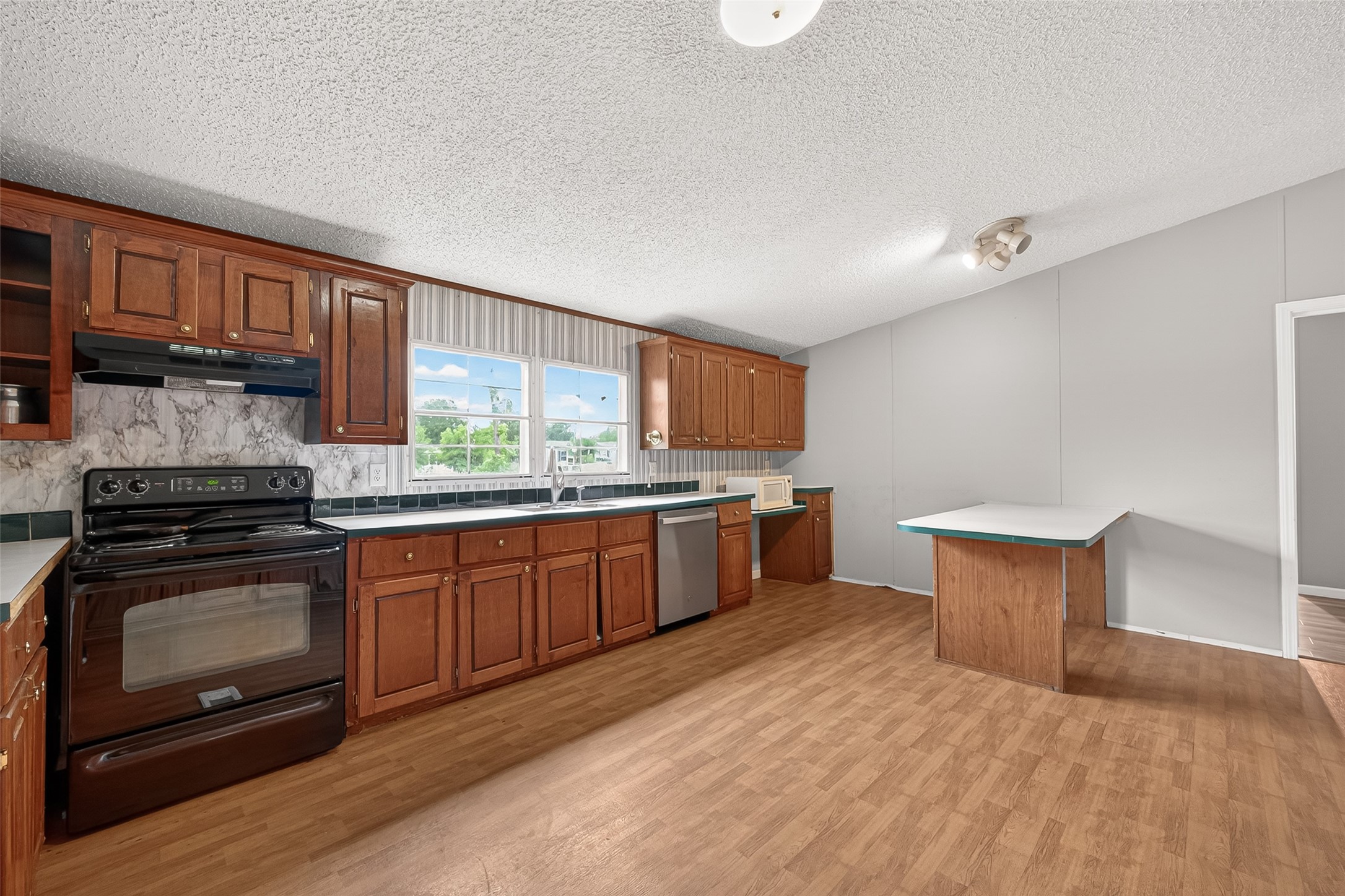 5982 Waukegan Road Conroe, TX 77306 - Photo 19 of 49 a kitchen with stainless steel appliances granite countertop a stove a sink and a microwave