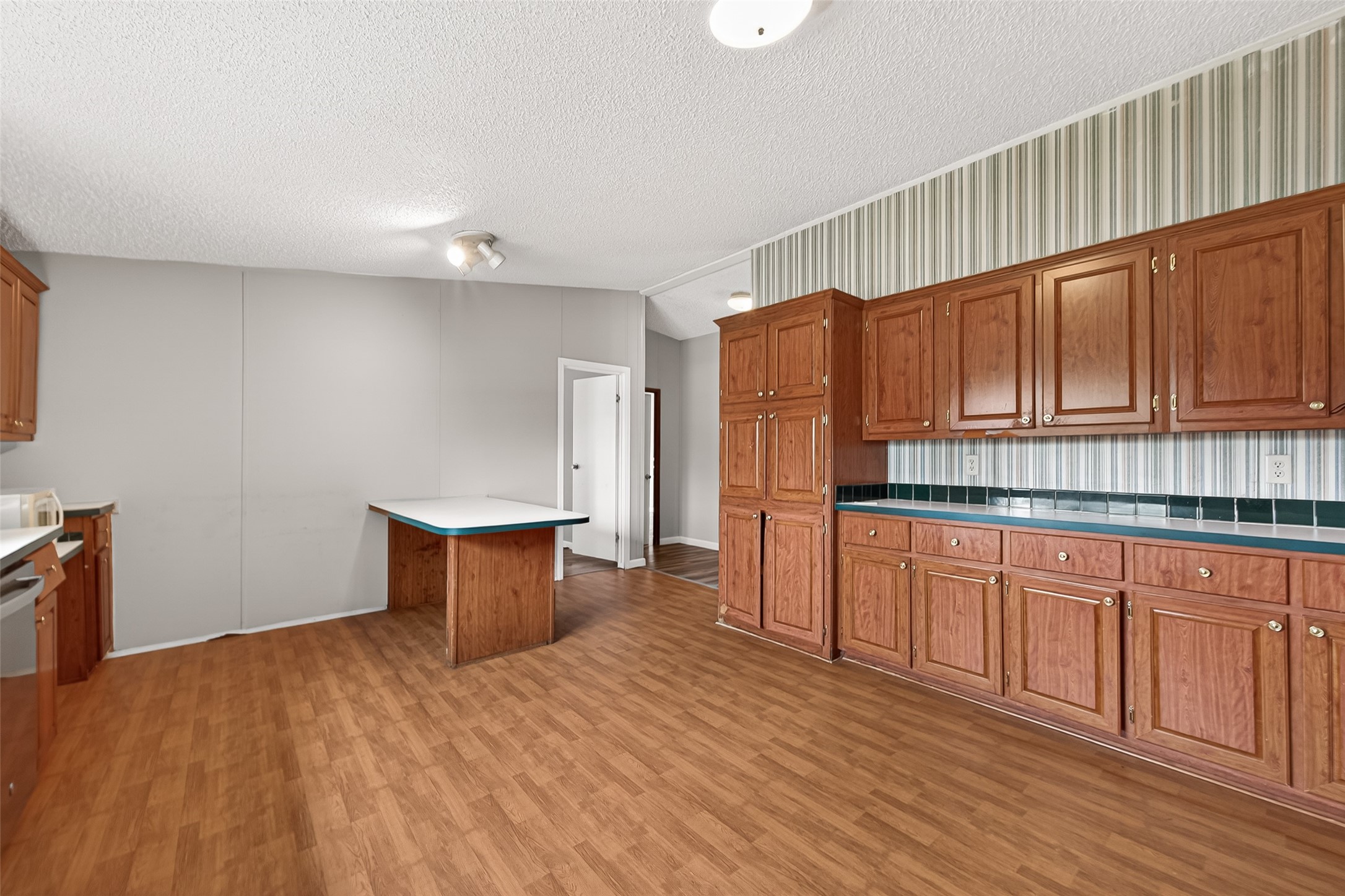 5982 Waukegan Road Conroe, TX 77306 - Photo 21 of 49 a kitchen with stainless steel appliances granite countertop a refrigerator a sink dishwasher and wooden cabinets with wooden floor