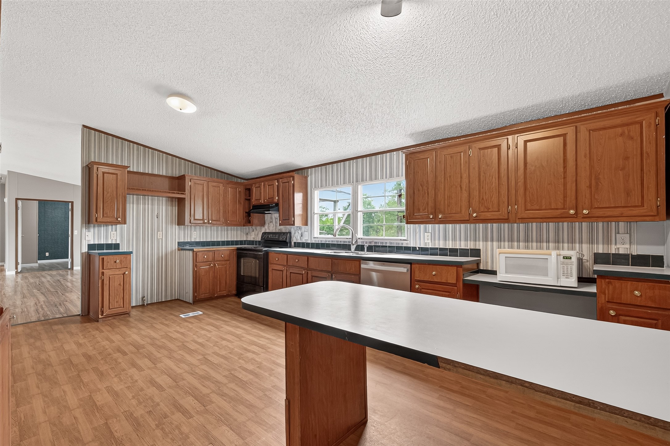 5982 Waukegan Road Conroe, TX 77306 - Photo 24 of 49 a kitchen with stainless steel appliances wooden cabinets a sink and a stove