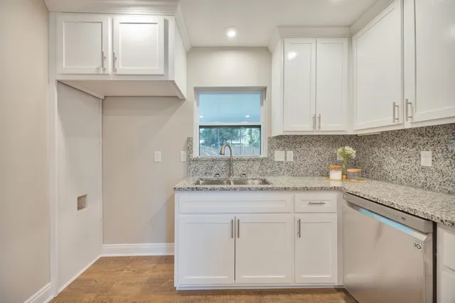 a kitchen with granite countertop white cabinets and white appliances