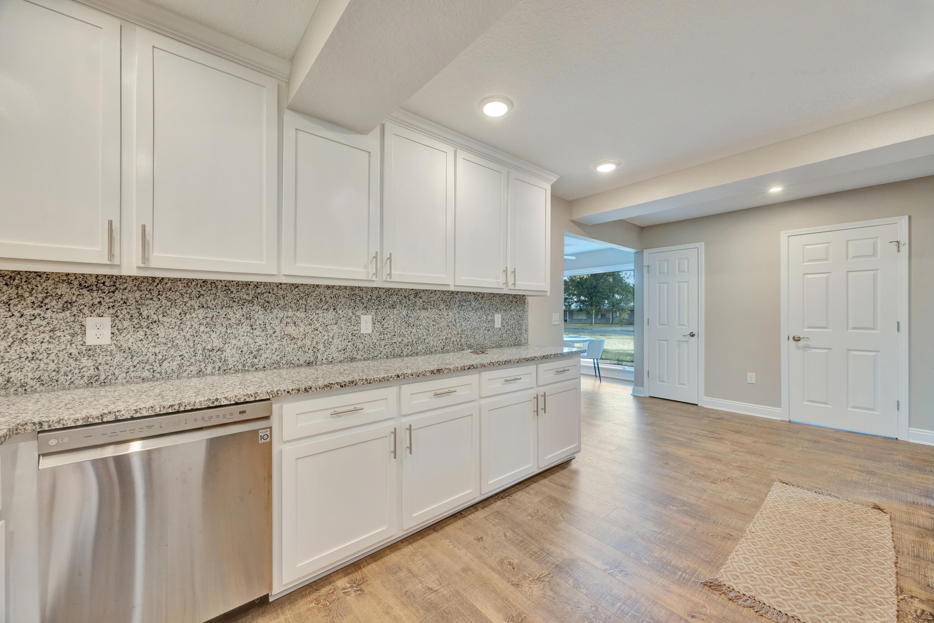 147 Gillis Drive Crestview, FL 32536 - Photo 18 of 62 a kitchen with white cabinets granite counter tops and a view of living room