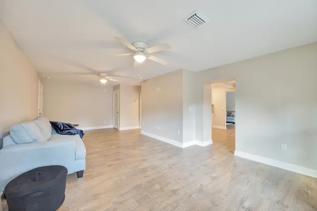 a white bed sitting in a bedroom next to a window