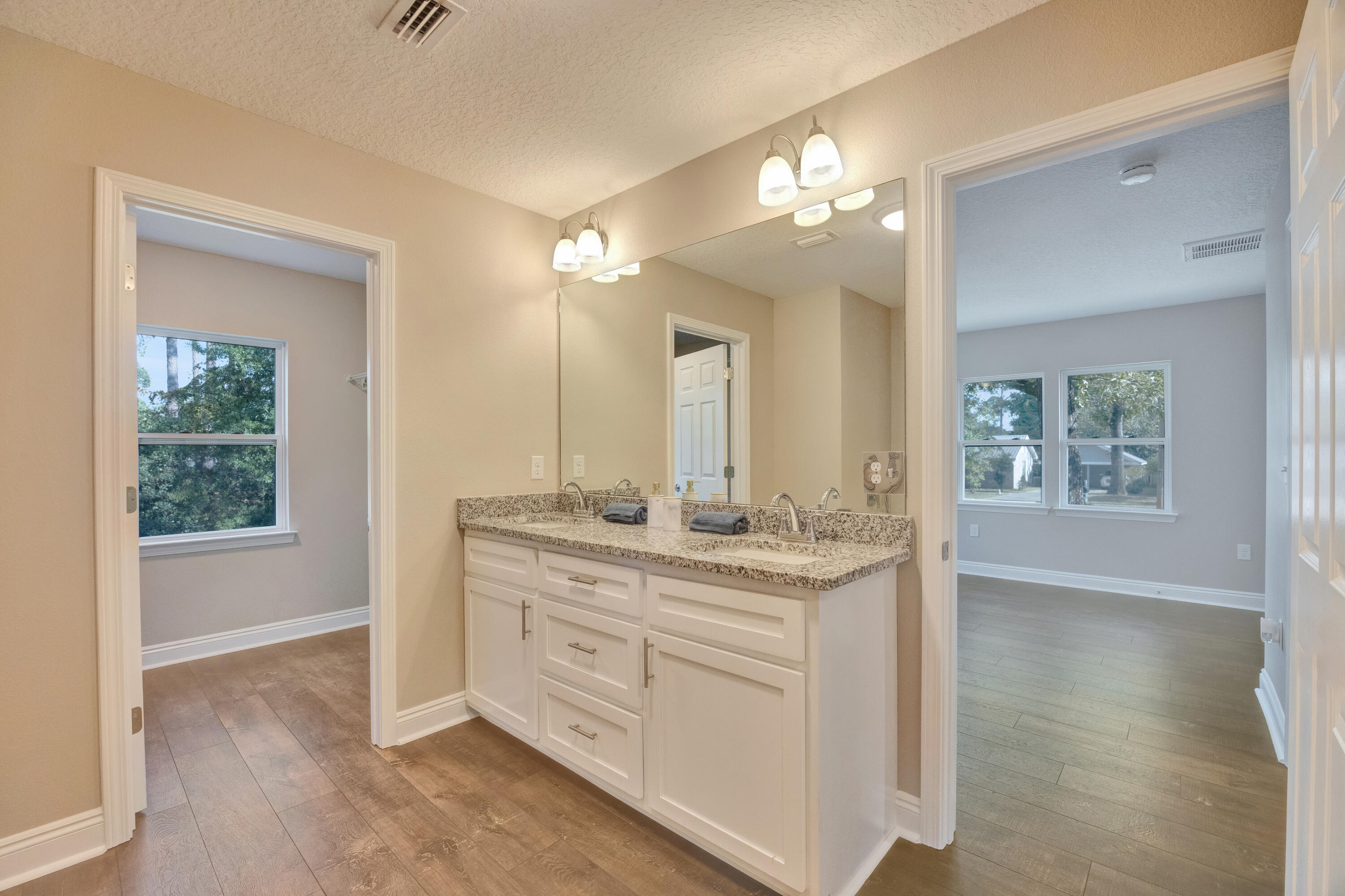 147 Gillis Drive Crestview, FL 32536 - Photo 32 of 62 a bathroom with a granite countertop sink a large mirror and a shower