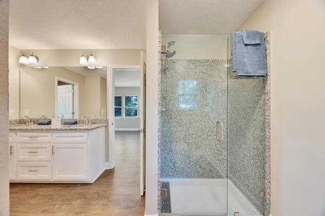 a bathroom with a granite countertop sink a large mirror and a light fixture