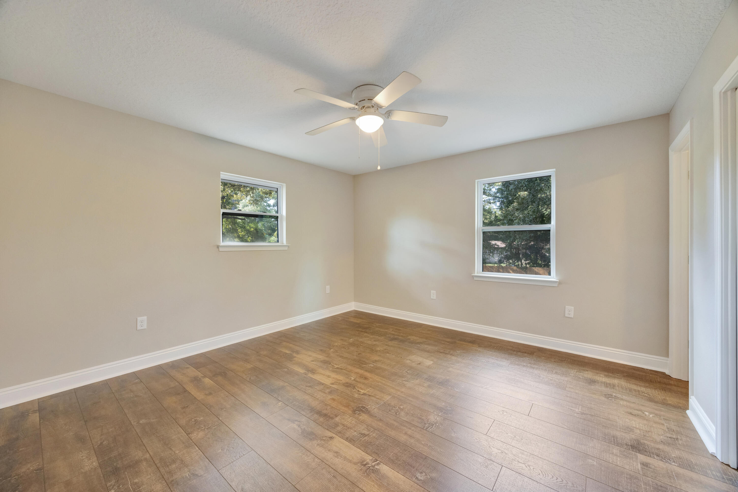 147 Gillis Drive Crestview, FL 32536 - Photo 43 of 62 an empty room with wooden floor and windows