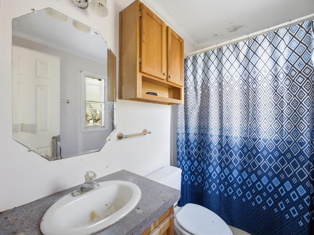 381 West McCool Road Nocona, TX 76255 - Photo 24 of 39 a bathroom with a sink and mirror with toilet