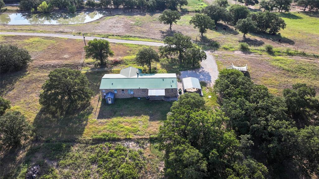 381 West McCool Road Nocona, TX 76255 - Photo 27 of 39 an aerial view of a house with a yard lake and outdoor seating