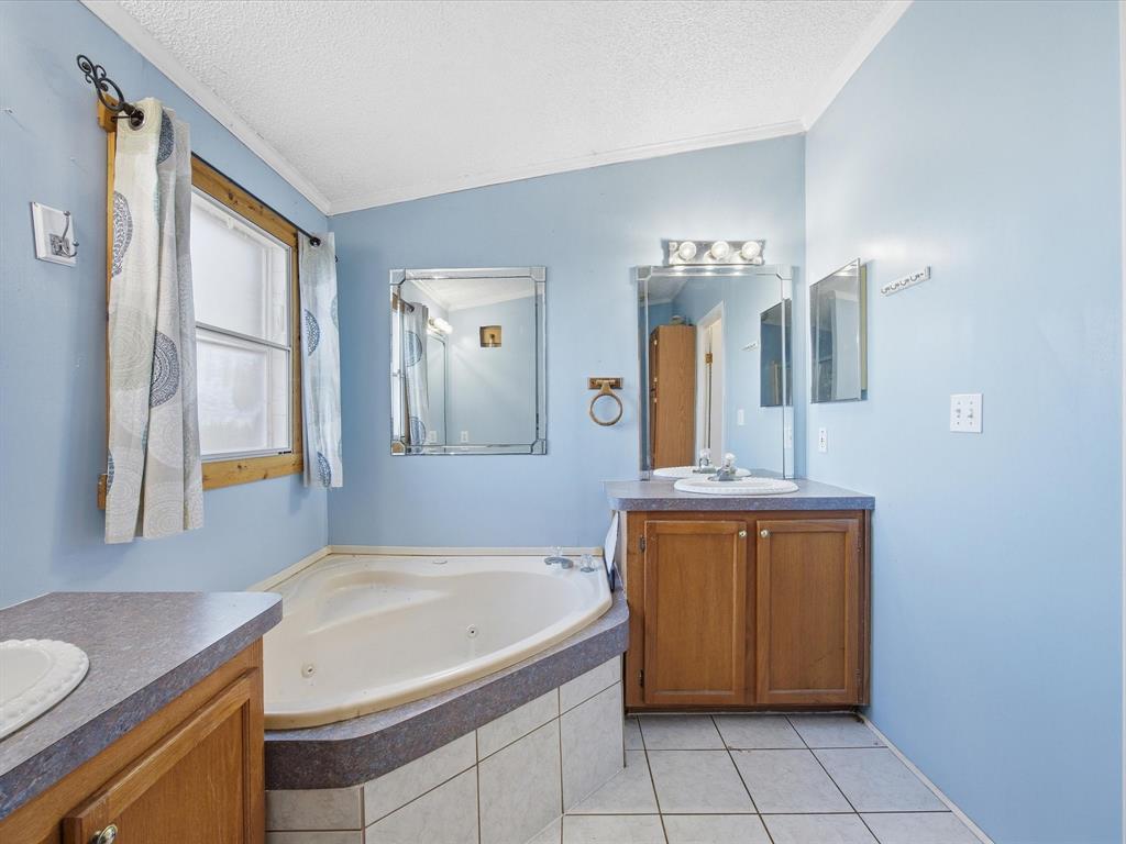 381 West McCool Road Nocona, TX 76255 - Photo 9 of 39 a bathroom with a granite countertop sink and a mirror