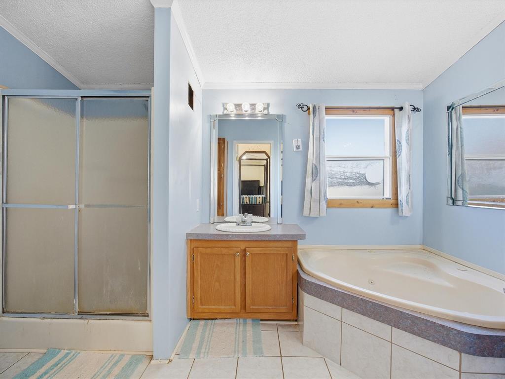 381 West McCool Road Nocona, TX 76255 - Photo 10 of 39 a bathroom with a tub a sink and a mirror