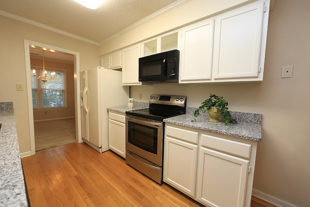 202 Bracken Court Raleigh, NC 27615 - Photo 6 of 19 Another view of this bright Kitchen featuring smooth-top stainless range and built-in microwave. Refrigerator conveys! Kitchen