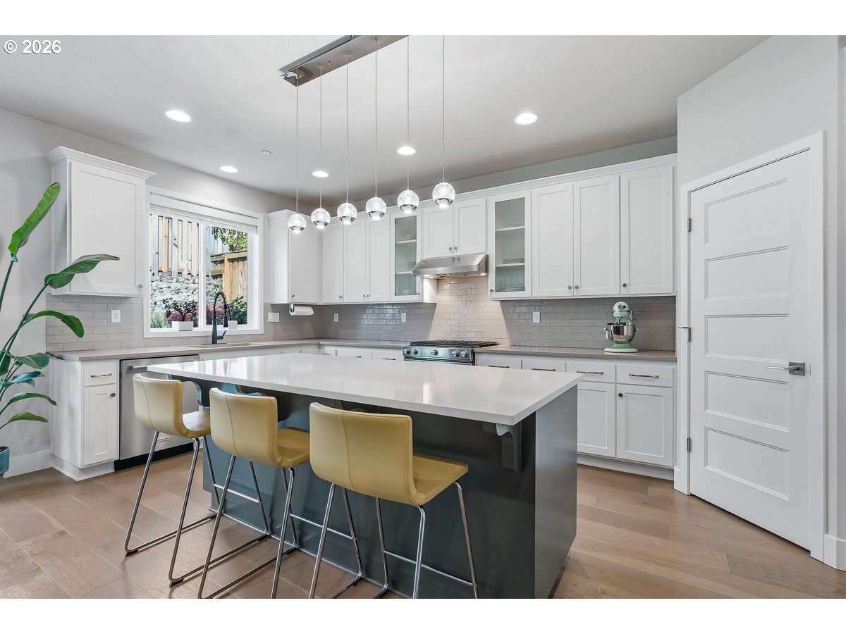 16275 Southwest Jade View Way Beaverton, OR 97007 - Photo 6 of 34 a kitchen with kitchen island granite countertop a table chairs sink and cabinets