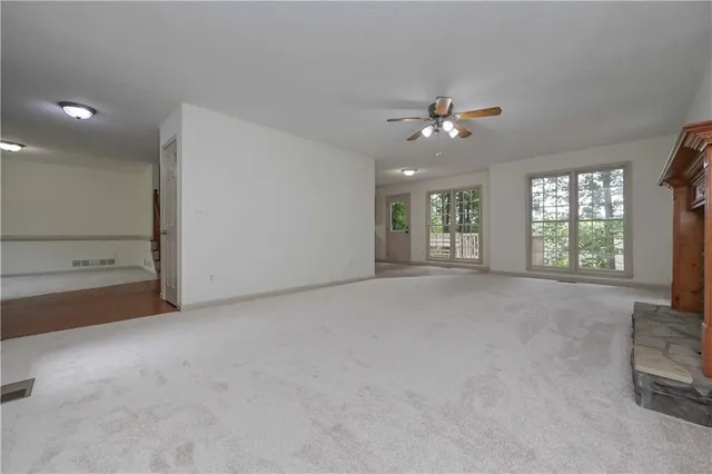an empty room with windows and ceiling fan