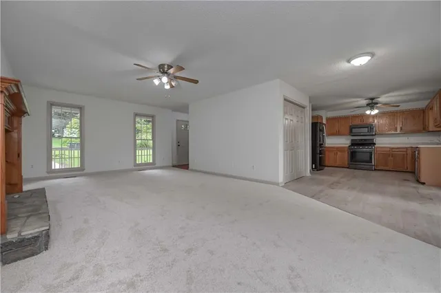 a view of a big room with windows and chandelier fan