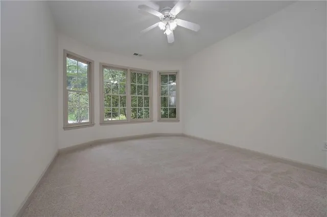 an empty room with a window and a ceiling fan