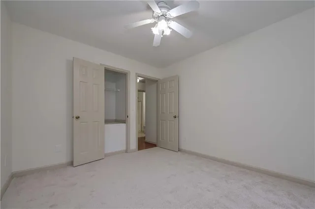 a view of an empty room and chandelier fan